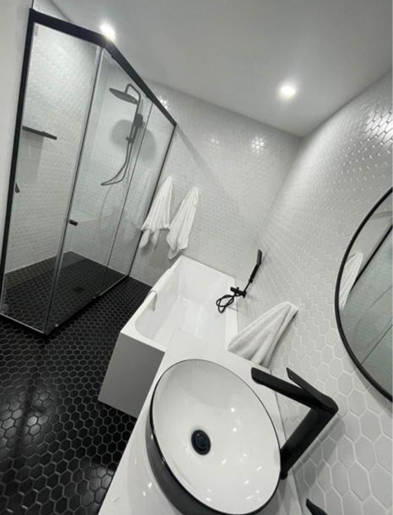 Bathroom renovation with black and white hexagon mosaic tile and matte black fittings