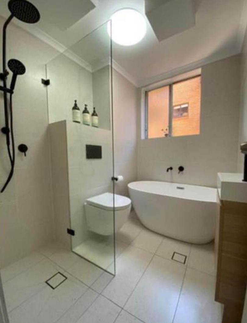 Completed A2Z bathroom renovation with a frameless walk-in shower, freestanding bath and window light